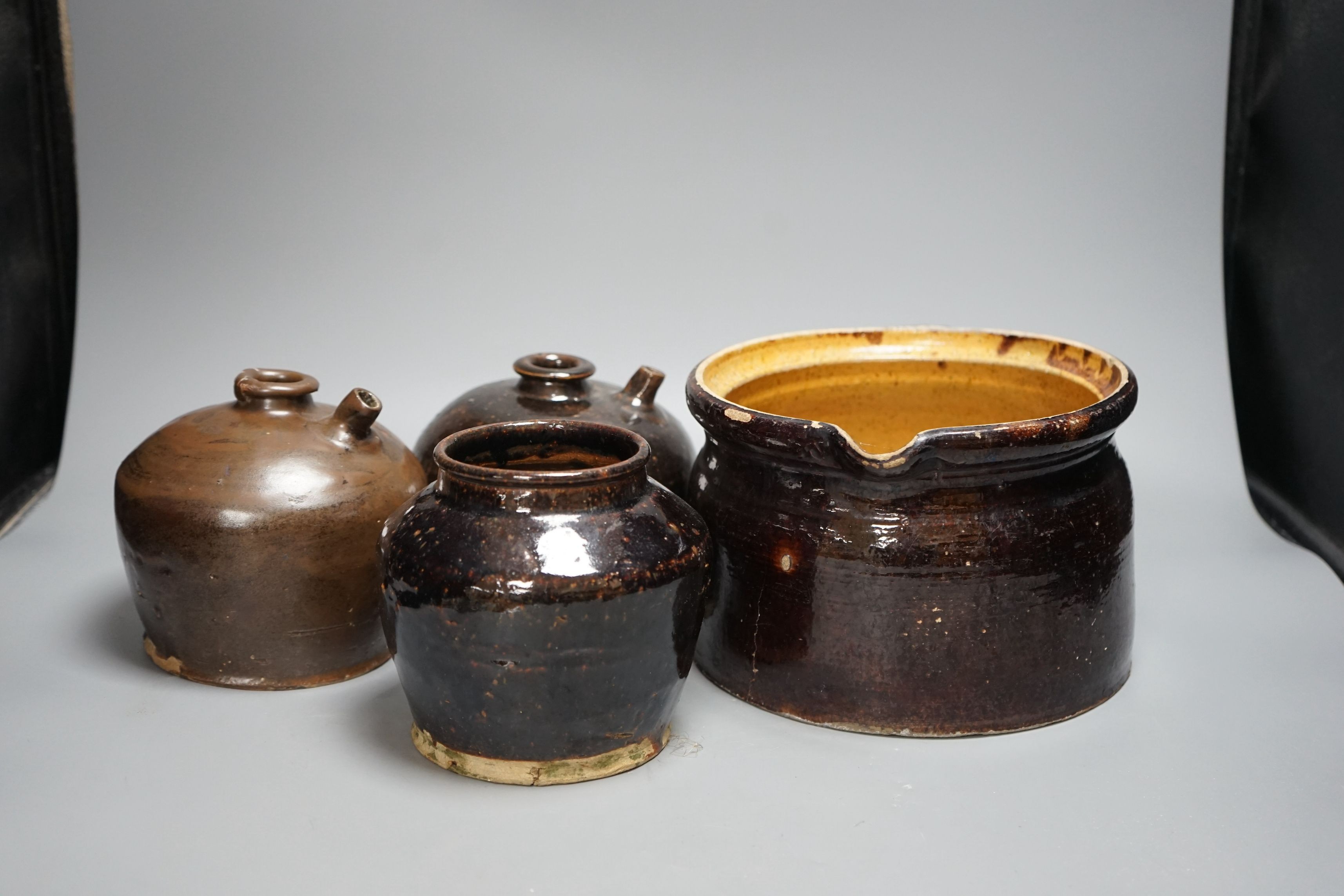 Two 19th century Chinese tenmoku glazed soy sauce jars, a similar jar and a pouring vessel, largest 14cm tall
